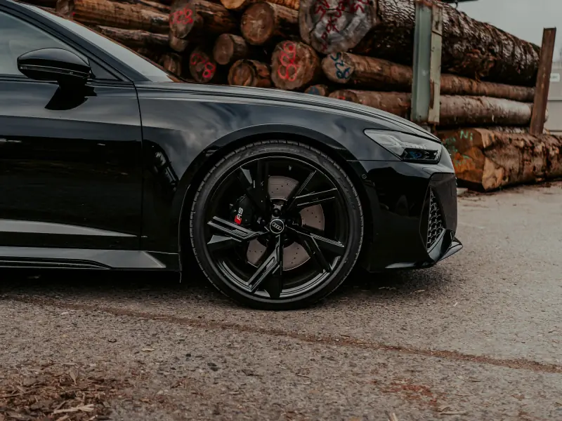 Audi RS6 Avant delante de un almacén de madera