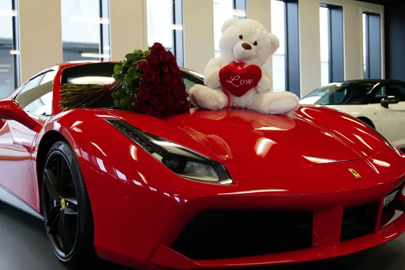 Red Ferrari with roses and a teddy bear for the handover